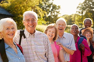 Happy group of seniors wearing hiking backpacks