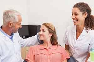 Patient having relaxed conversation with dental team members