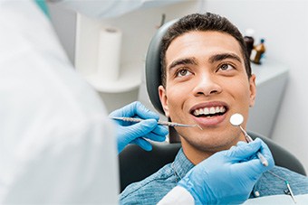 man smiling while getting dental checkup