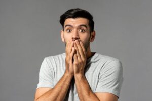 Concerned man covering his mouth with his hands